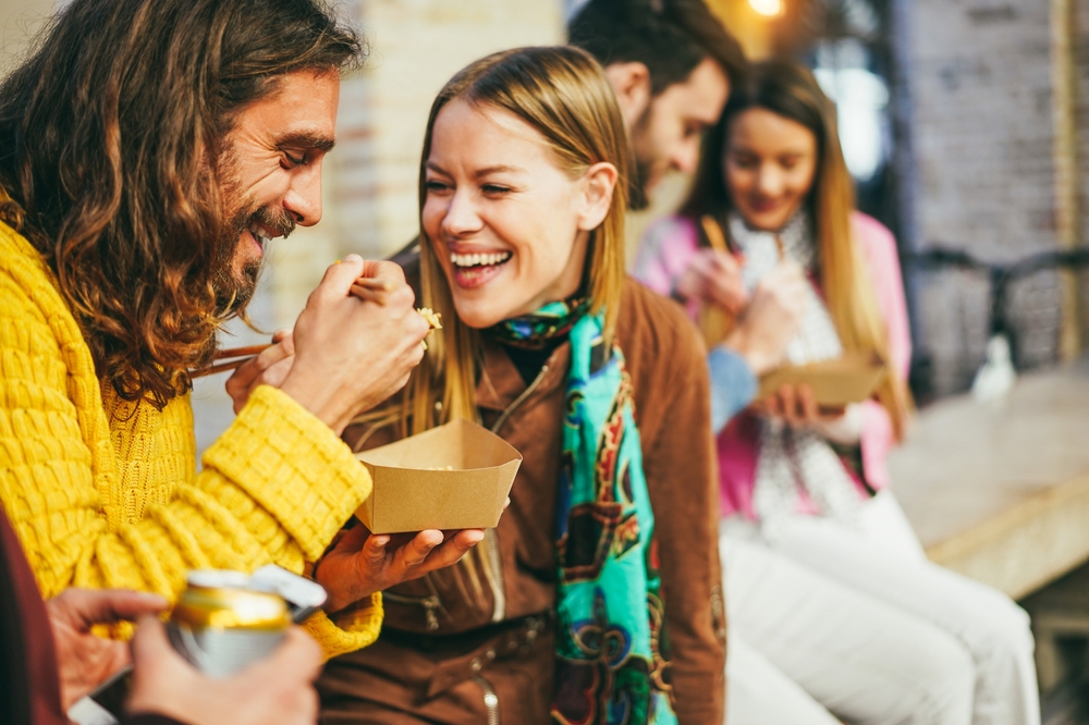 Paar beim Street-Food Essen ausprobieren