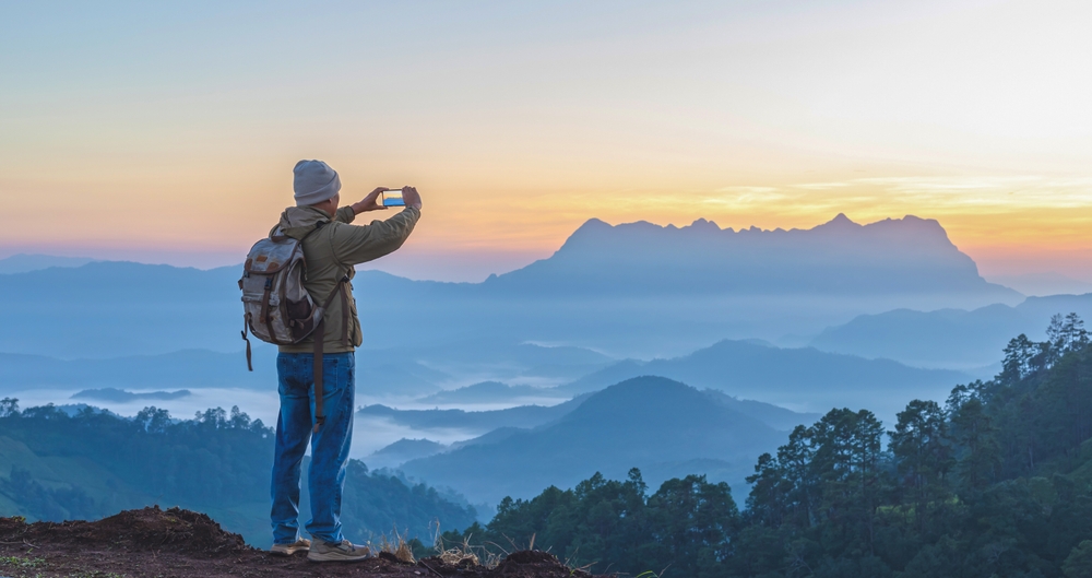 Mann macht Fotos im Gebirge