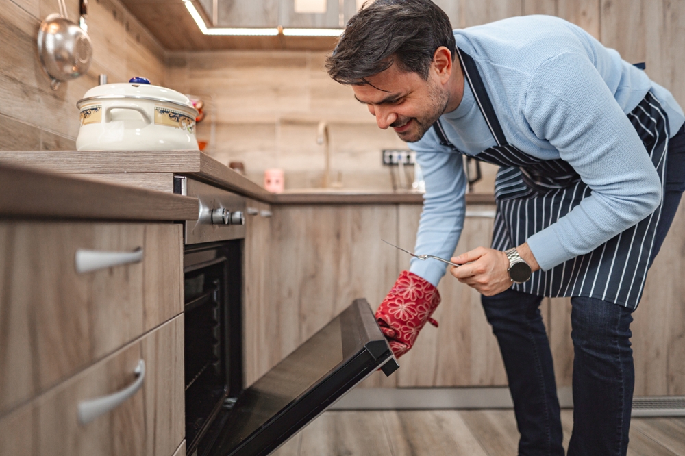 Kochende Kerle: Mann am Backofen