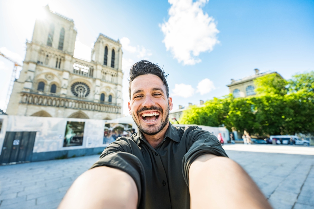Mann macht Selfie vor Notre Dame